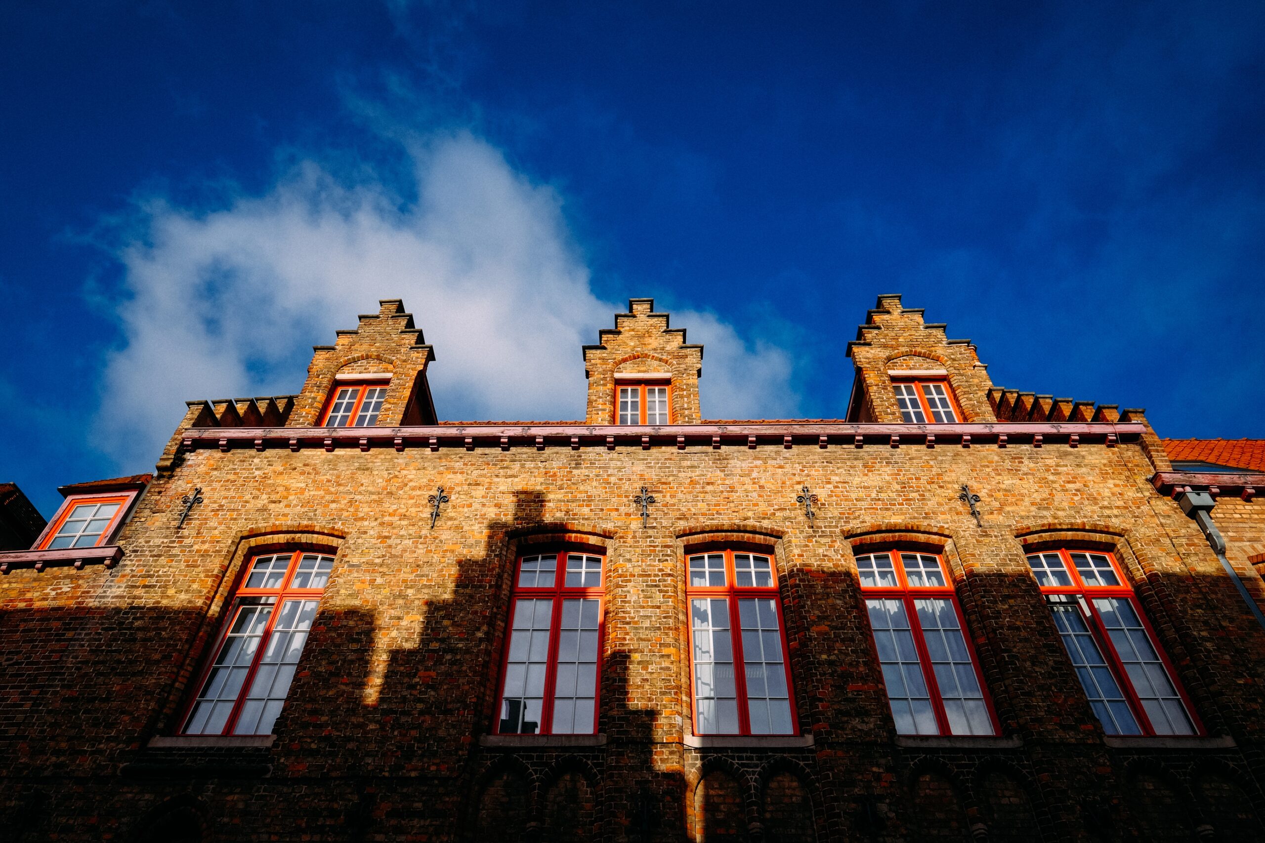 A low angle shot of a brown bricked made cathedral with windows at daytime